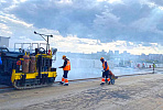 Cast asphalt is being laid on the cable-stayed section of a bridge under construction in Novosibirsk